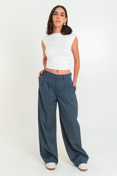 Pantalón de fit wide leg, cintura media con pretina y trabillas, pinzas frontales y bolsillos delanteros. Detalle de raya frontal y posterior. Cierre frontal con cremallera oculta, trabilla y botón en contraste.