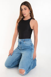 Pantalón wide leg de denim, cintura alta con pretina y trabillas, bolsillos delanteros y posteriores de parche. Cierre frontal con botón y cremallera oculta.