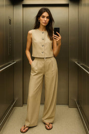 Pantalón de fit wide leg, pinzas frontales, cintura alta con pretina y trabillas, bolsillos delanteros y posteriores con vivos. Cierre frontal con botón y cremallera oculta.
