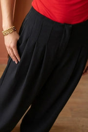 Pantalón de fit wide leg, cintura alta, pinzas frontales con raya, vivos decorativos posteriores, cierre frontal con broche y cremallera ocultos.