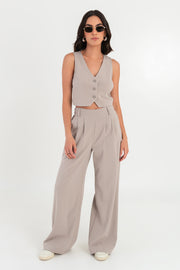 Pantalón de fit wide leg, cintura alta con pretina elástica posterior, trabillas, pinzas frontales y bolsillos delanteros.