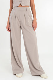 Pantalón de fit wide leg, cintura alta con pretina elástica posterior, trabillas, pinzas frontales y bolsillos delanteros.