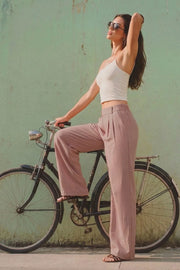 Pantalón de fit wide leg, cintura alta con pretina elástica posterior, trabillas, pinzas frontales y bolsillos delanteros.