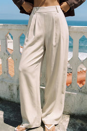 Pantalón de fit wide leg, cintura alta con pretina elástica posterior, trabillas, pinzas frontales y bolsillos delanteros.