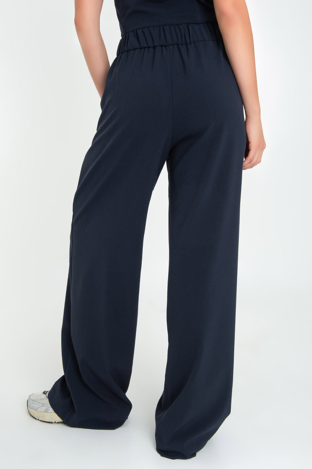 Pantalón de fit wide leg, cintura alta con pretina elástica posterior, trabillas, pinzas frontales y bolsillos delanteros.