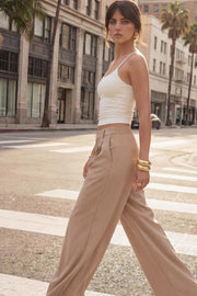 Pantalón de fit wide leg, cintura alta con pretina elástica posterior, trabillas, pinzas frontales y bolsillos delanteros.