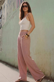 Pantalón de fit wide leg, cintura alta con pretina elástica posterior, trabillas, pinzas frontales y bolsillos delanteros.