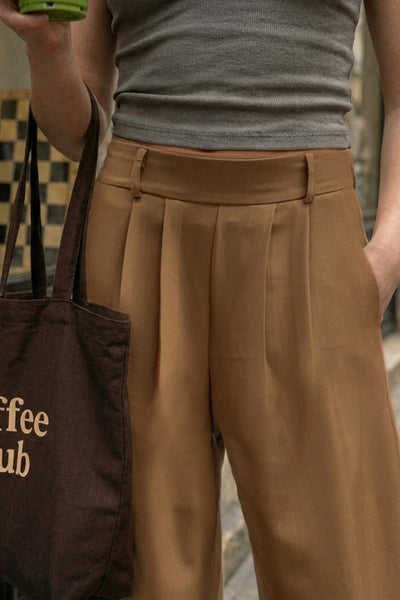 Pantalón de fit wide leg, cintura alta con pretina elástica posterior, trabillas, pinzas frontales y bolsillos delanteros.