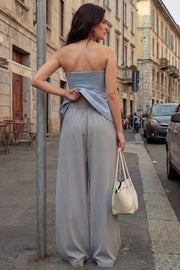 Pantalón de fit wide leg, cintura alta con pretina elástica posterior, trabillas, pinzas frontales y bolsillos delanteros.