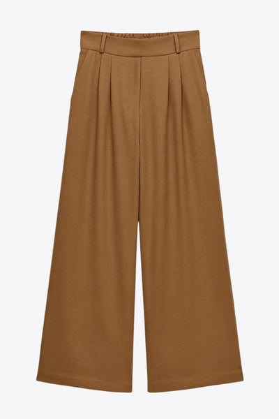 Pantalón de fit wide leg, cintura alta con pretina elástica posterior, trabillas, pinzas frontales y bolsillos delanteros.