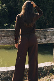 Pantalón de fit wide leg, cintura alta con pretina elástica posterior, trabillas, pinzas frontales y bolsillos delanteros.
