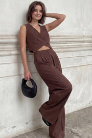 Pantalón de fit wide leg, estampado rayas, cintura alta, pinzas frontales, bolsillos delanteros, cierre frontal con botón y cremallera oculta.