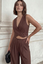 Pantalón de fit wide leg, estampado rayas, cintura alta, pinzas frontales, bolsillos delanteros, cierre frontal con botón y cremallera oculta.