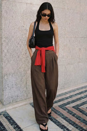 Pantalón de fit wide leg, pinzas frontales, cintura alta con pretina y trabillas, bolsillos delanteros, cierre frontal con broche y cremallera ocultos.