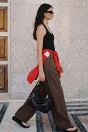 Pantalón de fit wide leg, pinzas frontales, cintura alta con pretina y trabillas, bolsillos delanteros, cierre frontal con broche y cremallera ocultos.