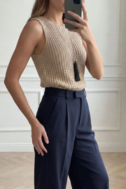 Pantalón de fit recto, pinzas frontales, cintura alta con pretina elástica posterior y trabillas, bolsillos delanteros, vivo decorativo posterior, cierre frontal con broche y cremallera ocultos.