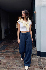 Pantalón wide leg de estampado rayas, cintura alta con pretina y trabillas, pinzas frontales, bolsillos delanteros y vivos decorativos posteriores. Cierre frontal con broche y cremallera ocultos. Detalle de trabillas ajustables con botón en costados.