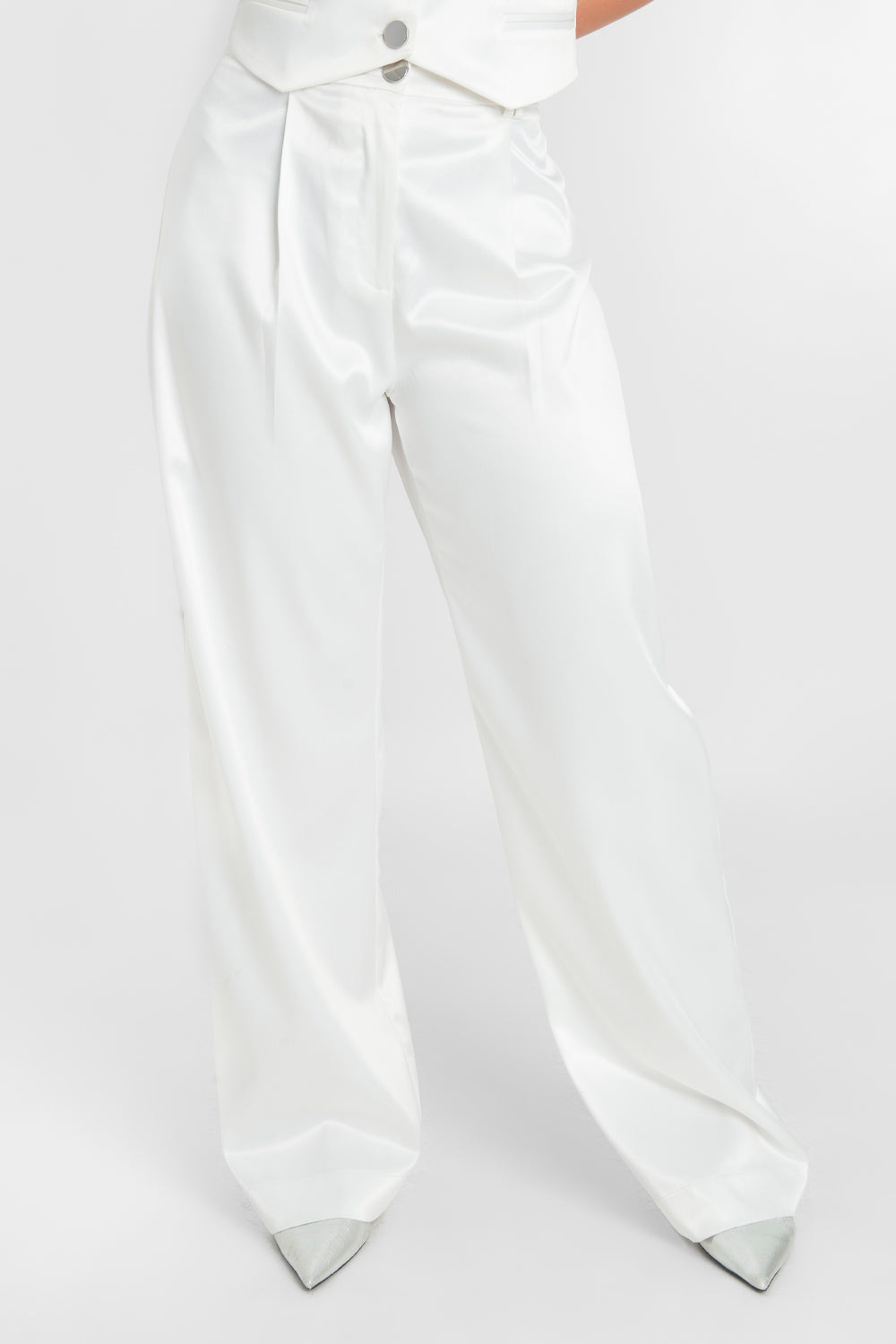 Pantalón satinado de fit wide leg con pinzas frontales, cintura alta con pretina y trabillas, bolsillos delanteros, cierre frontal con botón en contraste y cremallera oculta.