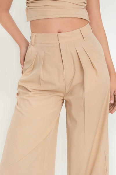 Pantalón de fit wide leg, cintura alta con pretina y trabillas, pinzas frontales, bolsillos delanteros, cierre frontal con broches y cremallera oculta.