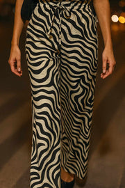 Pantalón estampado de fit fluido, bolsillos delanteros, cintura media con pretina elástica y jareta frontal ajustable.