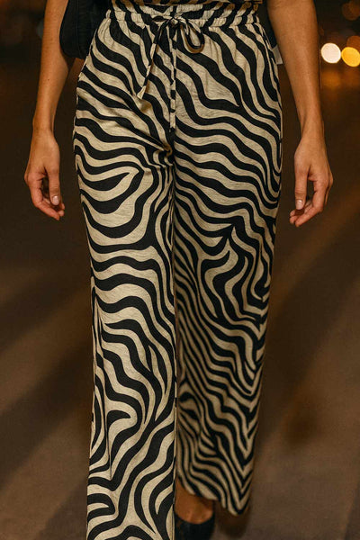 Pantalón estampado de fit fluido, bolsillos delanteros, cintura media con pretina elástica y jareta frontal ajustable.