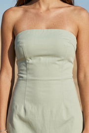 Playsuit strapless de fit ajustado, escote recto, pinzas frontales, lazo amarrable posterior y cierre con cremallera oculta.