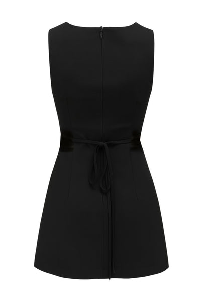 Playsuit de fit ajustado, cuello barco, sin mangas, pinzas frontales, lazo amarrable posterior y cierre con cremallera oculta.