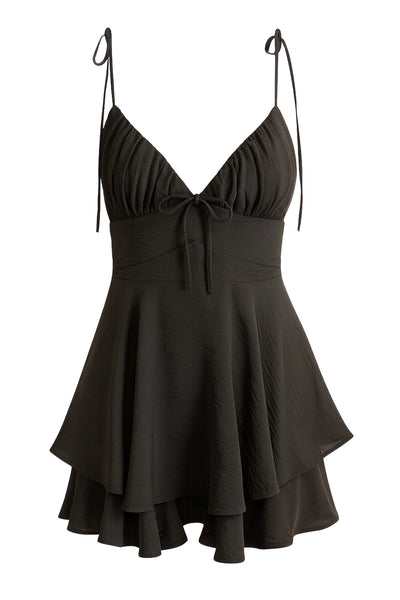 Playsuit de tirantes delgados con nudo amarrable, escote v con detalles plisados y lazo decorativo frontal, pretina cruzada frontal con lazo amarrable posterior y capas de olanes en bajo. Cierre posterior con cremallera visible en contraste.