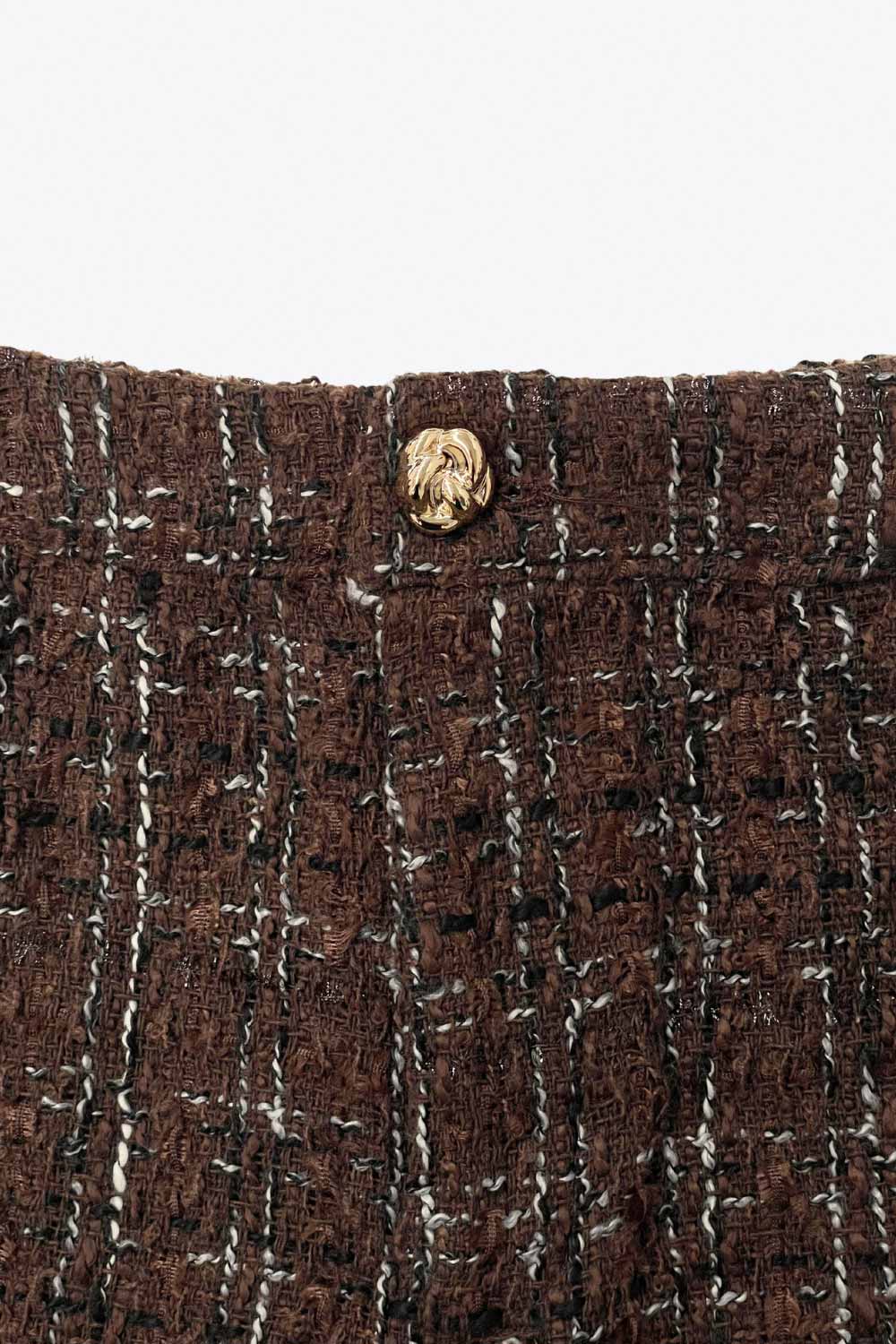 Short corto de bouclé, fit ajustado, cintura alta con pretina, cierre frontal con cremallera oculta y botón en contraste.