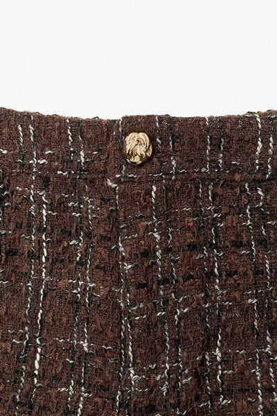 Short corto de bouclé, fit ajustado, cintura alta con pretina, cierre frontal con cremallera oculta y botón en contraste.