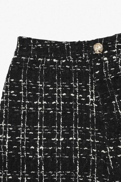 Short corto de bouclé, fit ajustado, cintura alta con pretina, cierre frontal con cremallera oculta y botón en contraste.