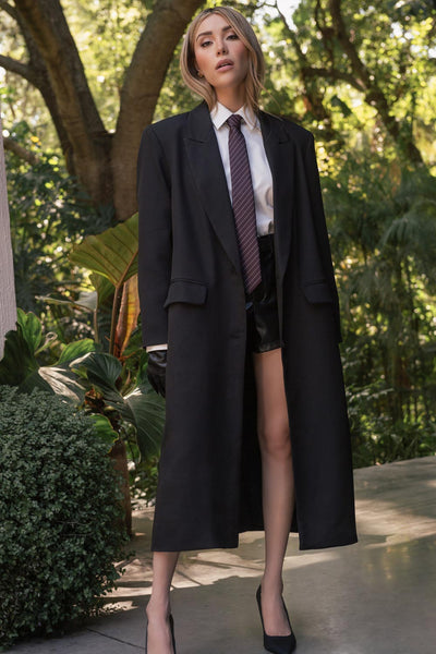 Short corto de efecto piel, fit ajustado, cintura alta con pretina y trabillas, bolsillos delanteros y vivos decorativos posteriores. Cierre frontal con botón y cremallera oculta.