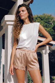 Short corto satinado de fit fluido, cintura media con pretina elástica y detalle de encaje decorativo en bajo.