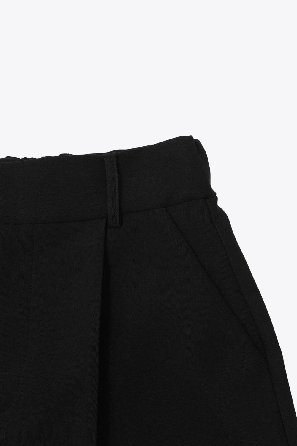 Short corto de cintura alta con pretina elástica posterior y trabillas, corte en a, pinzas frontales, bolsillos delanteros y vivo decorativo posterior. Cierre frontal con broche y cremallera oculta.