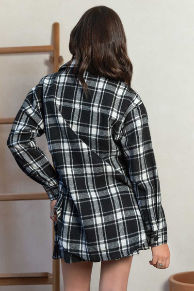 Sobrecamisa de fit oversized, estampado check, manga larga de puño abotonado, cuello camisero, bolsillos delanteros de parche con cartera y bajo curveado. Cierre frontal con hilera de botones en contraste.