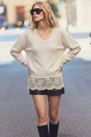 Suéter de punto, fit oversized, manga larga, cuello v, rib en bordes y detalle de encaje decorativo en bajo.