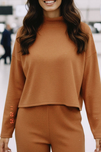 Jersey canalé de punto, fit oversized, cuello alto y manga larga amplia con hombro caído.