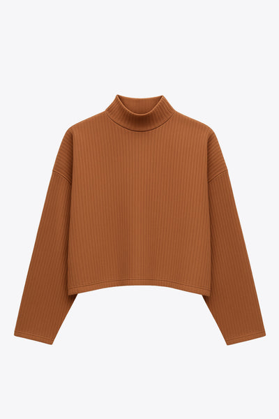 Jersey canalé de punto, fit oversized, cuello alto y manga larga amplia con hombro caído.