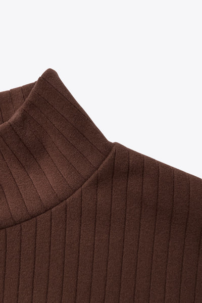 Jersey canalé de punto, fit oversized, cuello alto y manga larga amplia con hombro caído.