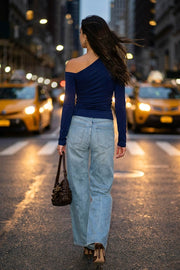 Top de fit ajustado, plisados en hombro, manga larga y cuello diagonal asimétrico con hombro descubierto.