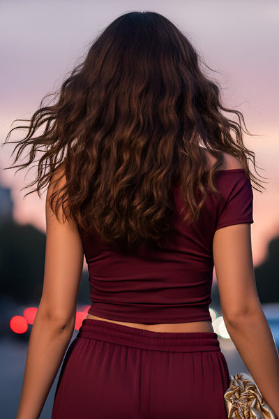 Top ajustado sin mangas, de cuello diagonal con hombro descubierto, plisados en hombros y bajo frontal asimétrico.