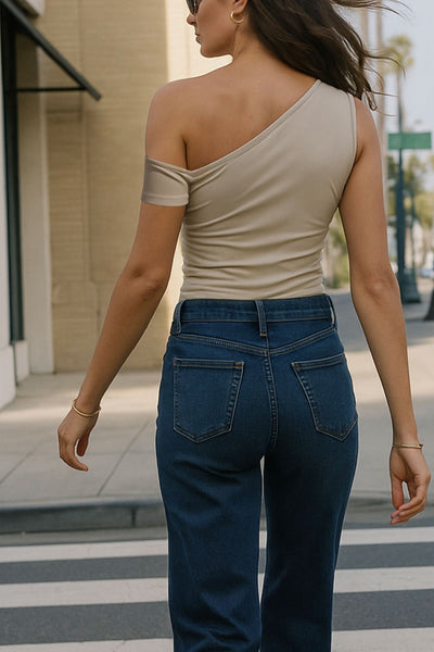 Top ajustado sin mangas, de cuello diagonal con hombro descubierto, plisados en hombros y bajo frontal asimétrico.