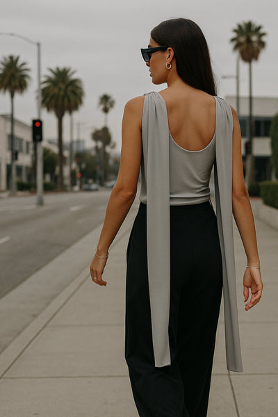 Top de fit ajustado, sin mangas, cuello redondo y detalle decorativo frontal con plisados en hombros.