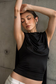 Top de fit ajustado, sin mangas, cuello redondo y detalle decorativo frontal con plisados en hombros.