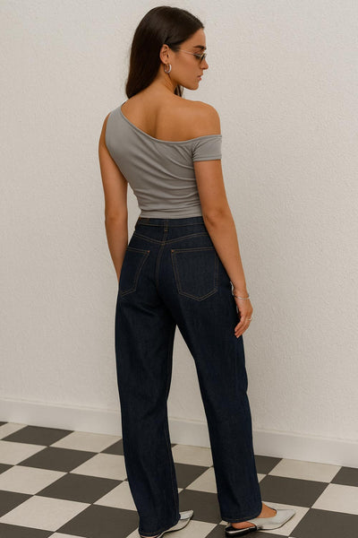 Top ajustado sin mangas, de cuello diagonal con hombro descubierto, plisados en hombros y bajo frontal asimétrico.