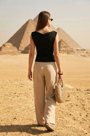 Top ajustado sin mangas, de cuello diagonal con hombro descubierto, plisados en hombros y costados.