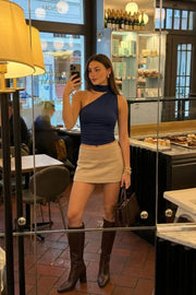 Top asimétrico de fit ajustado, detalles plisados laterales y en hombro, sin mangas, un hombro, escote diagonal y choker con plisados. Cierre posterior con botón y ojal.