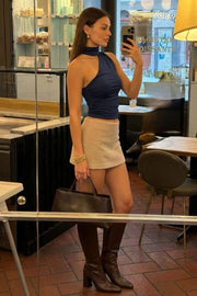 Top asimétrico de fit ajustado, detalles plisados laterales y en hombro, sin mangas, un hombro, escote diagonal y choker con plisados. Cierre posterior con botón y ojal.