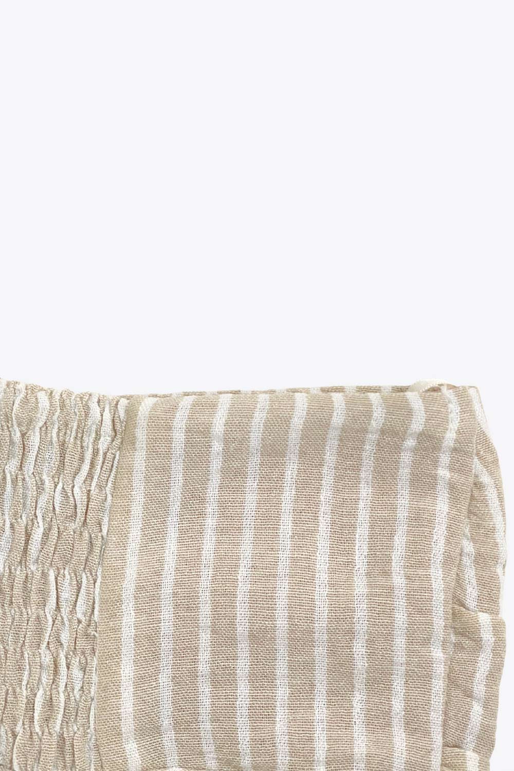 Top corto de estampado rayas, cuello halter con lazo amarrable posterior, escote corazón con jareta ajustable y plisados frontales. Detalle de peplum con olanes y fruncido en espalda.