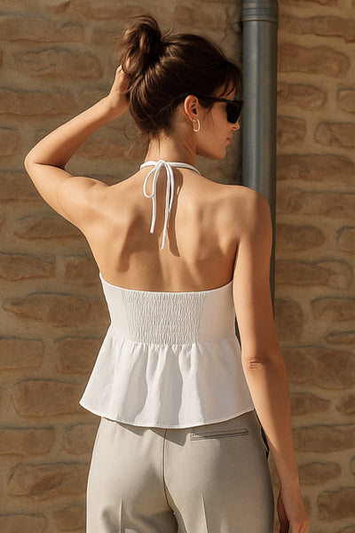 Top corto halter con lazo amarrable posterior, escote corazón con jareta ajustable y plisados frontales. Detalle de peplum con olanes y fruncido en espalda.